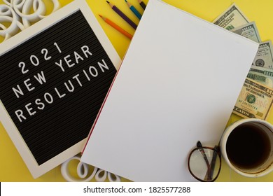 2021 New Year Resolution Office Concept On Yellow Desk With Notebook ,office Accessories And Money. Goal List 2021 With Change And Determination Concept. 2021 Budgeting.