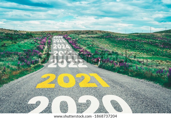2021 New Year road trip travel and future vision\
concept . Nature landscape with highway road leading forward to\
happy new year celebration in the beginning of 2021 for fresh and\
successful start .