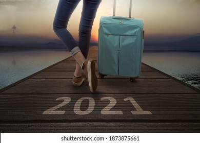 2021 On A Wooden Pier And Traveler Woman With A Suitcase. Happy New Year 2021