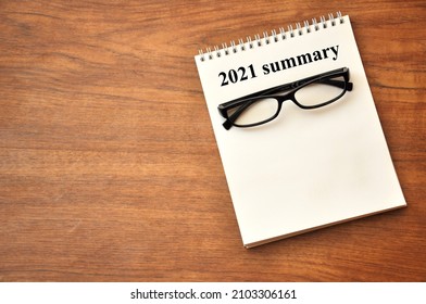 2021 Summary - Writing In A Notebook With Black Eyeglasses, Concept End Of Year Business