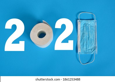 2021 Year, Blue Face Protective Masks And A Roll Of Toilet Paper On A Blue Background. Copy Space, Covid - 19