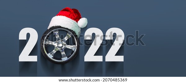 2022 Auto wheel in Santa\'s hat. New Year\
banner for auto workshop, auto shop. Copy space. Place for your\
text. Business.\
Background.