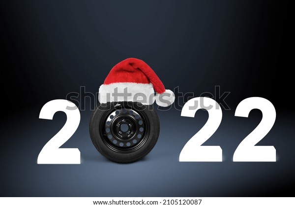 2022 Auto wheel in Santa\'s hat. New Year for auto\
workshop, auto shop.