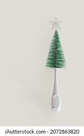 2022 Baby Bottle Cleaning Brush Like A Green Christmas Tree With A Silver Star On A Top. Minimal Abstract Winter New Years Scene Isolated On Beige Background. Greeting Card Or Gift Card Idea.