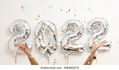 2022 Celcebration With Helium Ballons And Hands Throwing Confetti White Light Background