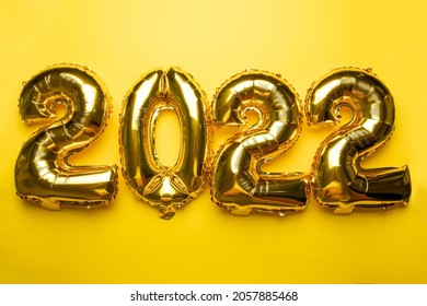 2022 Concept New Year from golden foil balloon on yellow background stock photo