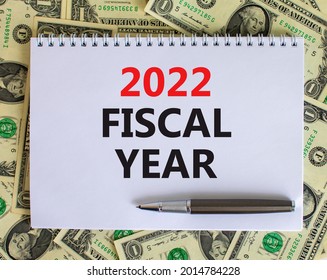 2022 Fiscal New Year Symbol. White Note With Words 2022 Fiscal Year On Beautiful White Background, Dollar Bills, Metallic Pen. Business And 2022 Fiscal New Year Concept.