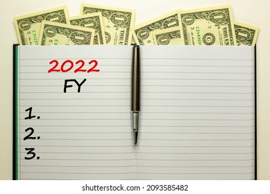 2022 FY Fiscal New Year Symbol. White Note With Words 2022 FY Fiscal Year On Beautiful White Background, Dollar Bills, Metallic Pen. Business And 2022 FY Fiscal New Year Concept.