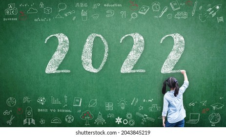 2022 Happy new year school class academic calendar with student kid's hand drawing greeting on teacher's green chalkboard for educational celebration, back to school, STEM education classroom schedule