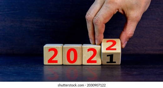 2022 happy new year symbol. Businessman turns a cube, symbolize the change from 2021 to the new year 2022. Beautiful black background. Copy space. Business and 2022 happy new year concept. - Shutterstock ID 2030907122