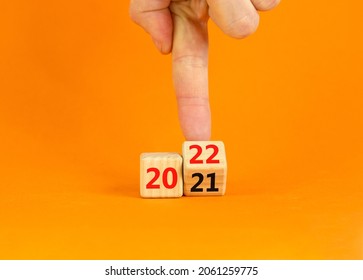 2022 happy new year symbol. Businessman turns a cube, symbolize the change from 2021 to the new year 2022. Beautiful orange background. Copy space. Business and 2022 happy new year concept. - Shutterstock ID 2061259775