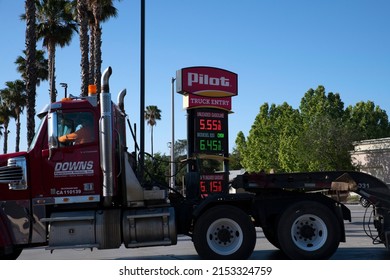 2022 May USA: Driver Of A Big Rig Truck Arriving At Pilot Truck Stop In California To Fuel Up. Sign With Gas And Diesel Prices Displayed. 