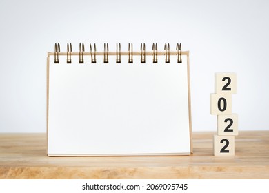 2022 mockup notepad and 2022 cubes wooden on table background, plans for New Year 2022 and space for your text on notepad, mockup calendar can useful in daily life. - Shutterstock ID 2069095745