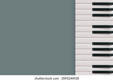2022. Musical border with square copy space made of piano keys isolated on gray background. Minimal flat lay. Creative abstract concept. Music festival, concert or piano training note card. Top view. 