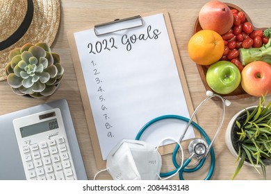 2022 New Year Goals In New Normal Lifestyle, Work-life Balance With Face Mask Safety From Covid-19, Healthy  Cholesterol Diet Food, Good Heart Health On Blank Resolution List On Paper Medical Notepad