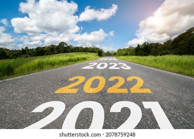 2022 New Year road trip travel and future vision concept . Nature landscape with highway road leading forward to happy new year celebration in the beginning of 2022 for fresh and successful start . - Shutterstock ID 2078759248
