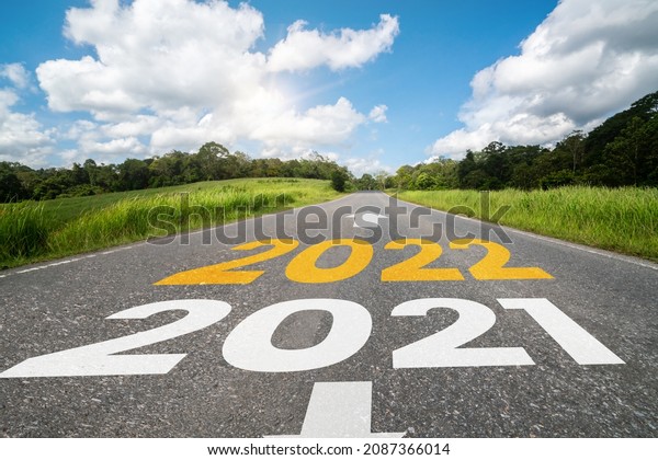 2022 New Year road trip travel and future vision\
concept . Nature landscape with highway road leading forward to\
happy new year celebration in the beginning of 2022 for fresh and\
successful start .