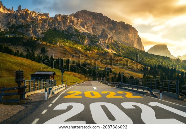 2022 New Year road trip travel and future vision\
concept . Nature landscape with highway road leading forward to\
happy new year celebration in the beginning of 2022 for fresh and\
successful start .