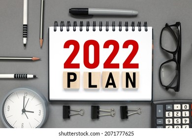 2022 plan. the inscription on the notebook. business concept. notepad on a gray background. glasses, pen, pencil, watch, calculator - Shutterstock ID 2071777625