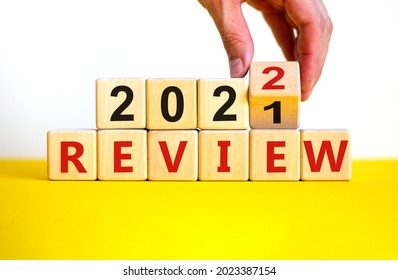 2022 review new year symbol. Businessman turns a wooden cube and changes words 'Review 2021' to 'Review 2022'. Beautiful white background, copy space. Business, 2022 review new year concept.