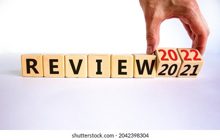 2022 review new year symbol. Businessman turns wooden cubes and changes words 'Review 2021' to 'Review 2022'. Beautiful white background, copy space. Business, 2022 review new year concept.