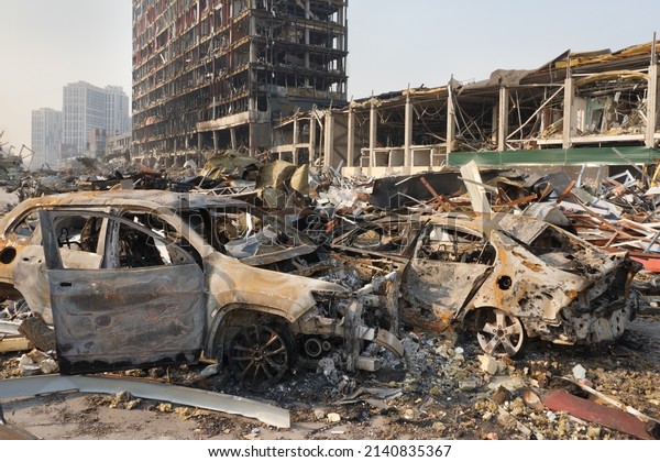 2022 Russian invasion of Ukraine war torn city\
destroyed car burn out. Russia war damage building destruction city\
war ruins city damage car. Terror attack bomb shell of civilian\
bombed. Disaster area