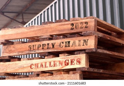 2022 Supply Chain Challenges, text written on piled-up pallets, supply chain management concept - Shutterstock ID 2111601683