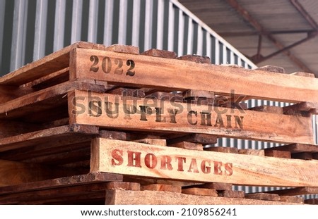2022 Supply Chain Shortages, text written on piled-up pallets, supply chain management concept