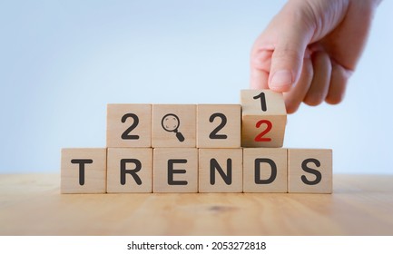 2022 trend concept. Hand flip wooden cube change year 2021 to 2022. Beautiful white background, copy space. Used for banner in trend concept in new year for monitoring new business opportunities. - Shutterstock ID 2053272818