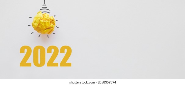 2022 with Yellow paper light bulb, innovative business vision and resolution concept