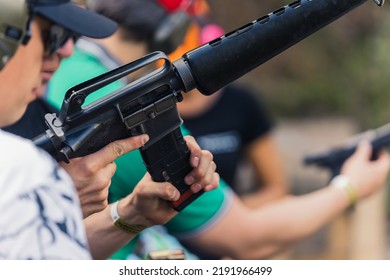 2022.08.07 Modlin, Poland - Group Of People Training How To Operate Guns. Firearm Training At Firing Range. Safety Gear. Close-up Of Submachine Gun. Outdoor Horizontal Shot . High Quality Photo