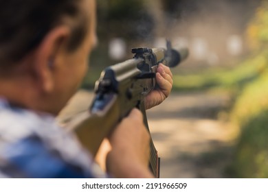 2022.08.07 Modlin, Poland - Rear View Of Man Training Aim On Shooting Range Using Ak47. Blurred Foreground. Outdoor Horizontal Shot. High Quality Photo