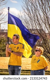 2022_03_05 Tulsa, OK USA - Young Man Holding Ukrainian Flag And Older Woman In Blue Jeans And Yellow Tee-shirts At Rally To Support Ukraine