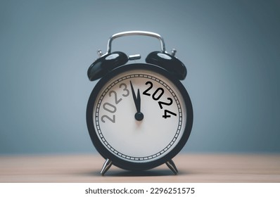 2023 and 2024 on black alarm clock on wooden table with copy space  for preparation of Merry Christmas and Happy new year concept. - Shutterstock ID 2296251575