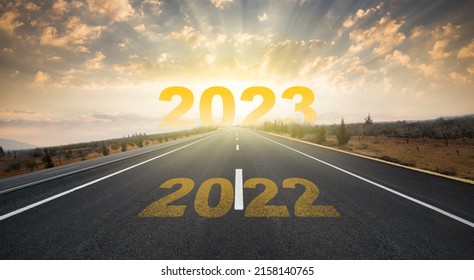 2023 anniversary. Transition from 2022 to the new year. Golden sunrise on asphalt empty road. New year concept with the number 2023 on the horizon. - Shutterstock ID 2158140765