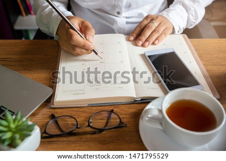 2023 Calendar and diary, Planner writing daily appointment. Woman plan and noted schedule book (holiday trip) on book at home office. Calendar reminder event for planner concept