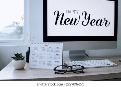 2023 calendar with Happy New Year text on computer screen on the background - Shutterstock ID 2229036275