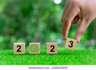 2023. Enviromental Sustainability Target. Hand Puts Wooden Cubes With Number 3 Icons With 2023 Icons On Green Background. Green Community. Goals,plan,opportunity, New Green, Business,social,time.