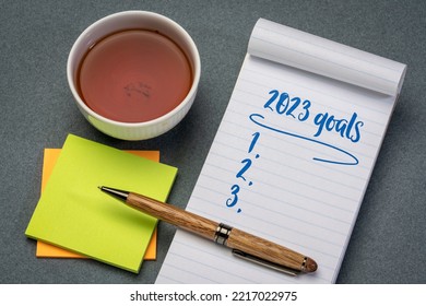 2023 goals list in a notebook with pen and reading glasses, setting New Year goals and resolutions - Shutterstock ID 2217022975