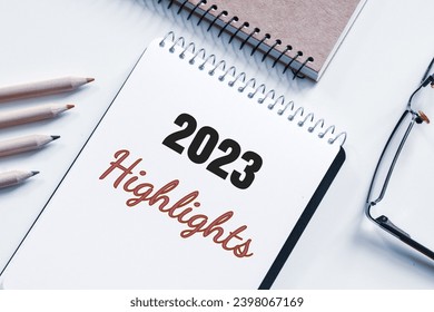 2023 Highlights inscription on notepad on desk. Top events of the year, recap, assessment evaluation of year 2023 concept.