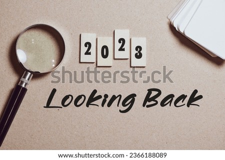 2023 Looking Back inscription on wooden chips on desk. Brown background, top view. 2023 review recap highlights of the year concept.