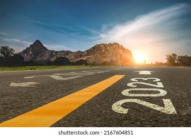 2023 ,new year 2023 or beginning of 2023 word concept written on a road in the middle of a country road with mountains sunset concept backdrop.