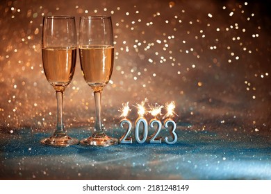 2023 New Year. Happy new year 2023 greeting card. Champagne glasses on glitter background,