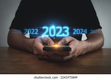 2023. people hand touching on mobile smartphone with with virtual screen change from 2022 to 2023, strategy, investment, business planning and happy new year, digital business technology concept - Shutterstock ID 2241975849