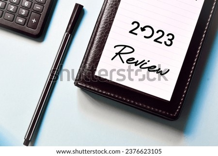 2023 Review note on sky blue background. Recap, assessment, look back and highlights of the year concept.