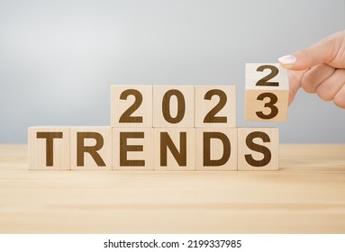 2023 trend concept. Hand flip wooden cube change year 2022 to 2023. gray background, copy space. 2022 trends concept. Hand flip wooden cube change on desk