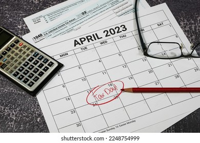2023 US tax day calendar reminder with tax forms, calculator and glasses. - Shutterstock ID 2248754999