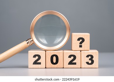 2023 wood cubes with question symbol and magnifying glass, analysis what will happen in 2023, product review and forecast, trend concept - Shutterstock ID 2224391619