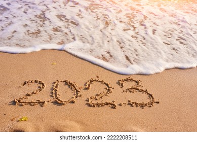 2023 year written on sandy beach sea at sunny day