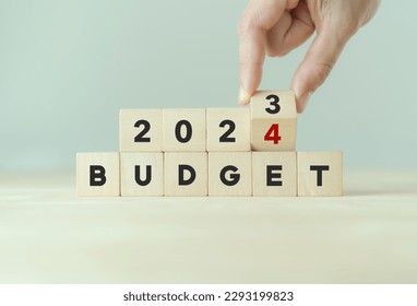 2024 Budget planning and allocation concept. Hand flips wooden cube and changes the inscription 